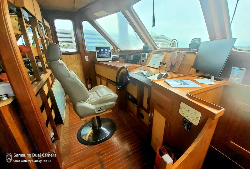 Slide: The Image of 1989 DeFever 57 POC Motor Yacht helm with modern navigation equipment and comfortable captain's chair. - 27