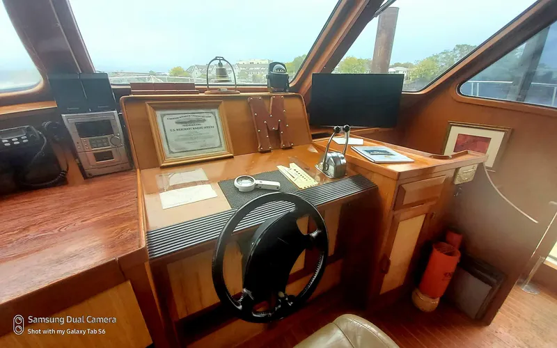 Slide: The Image of 1989 DeFever 57 POC Motor Yacht helm with steering wheel, navigation equipment, and wooden dashboard. - 29