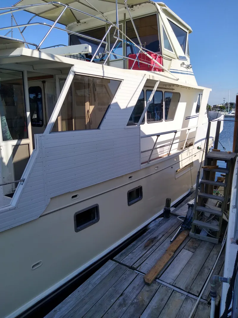 Slide: The Image of 1989 DeFever 57 POC Motor Yacht docked, showcasing its elegant design and spacious deck. - 5