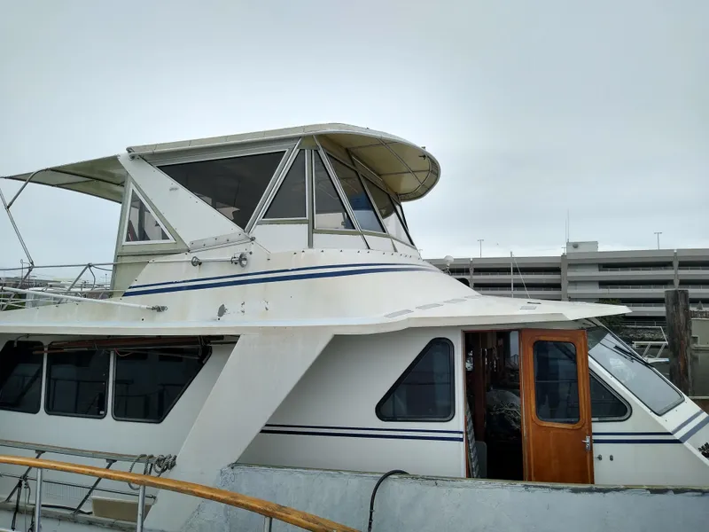 Slide: The Image of 1989 DeFever 57 POC Motor Yacht docked, featuring upper deck and cabin windows. - 6
