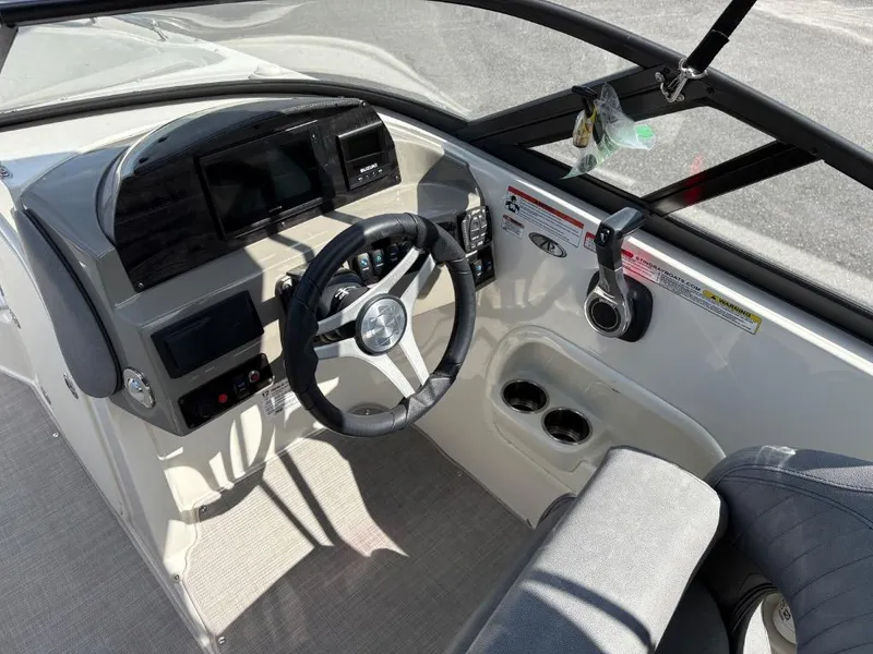 Slide: The Image of 2021 Stingray 231 DC boat dashboard with steering wheel and controls. - 10