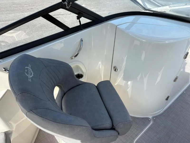 Slide: The Image of 2021 Stingray 231 DC boat interior with gray seating and white paneling. - 12