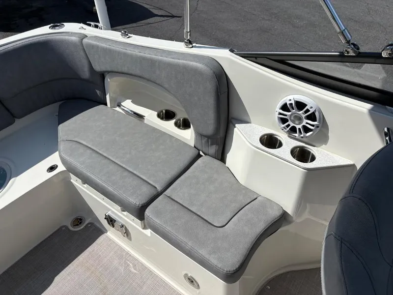Slide: The Image of 2021 Stingray 231 DC boat interior with gray seating, cup holders, and speaker. - 13