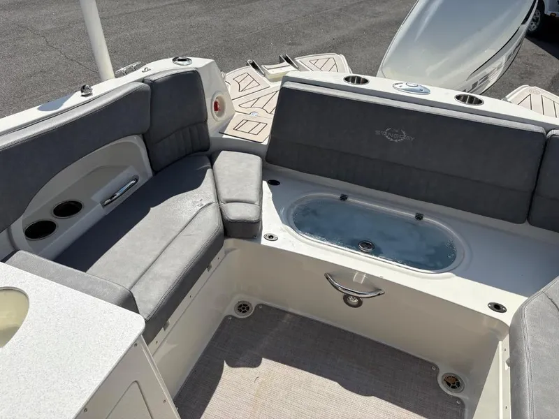 Slide: The Image of 2021 Stingray 231 DC boat interior with cushioned seating and built-in cup holders. - 14