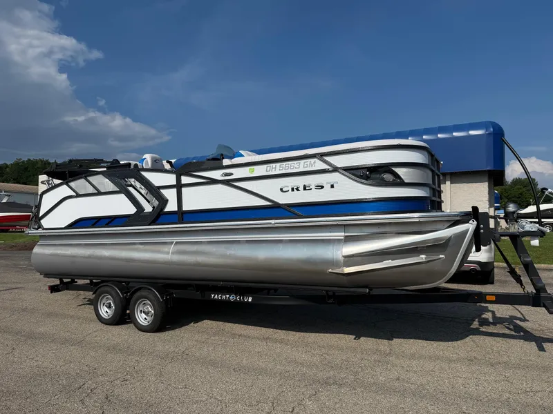 The Image of 2023 Crest Caribbean RS 230 pontoon boat on trailer under clear blue sky. - 0