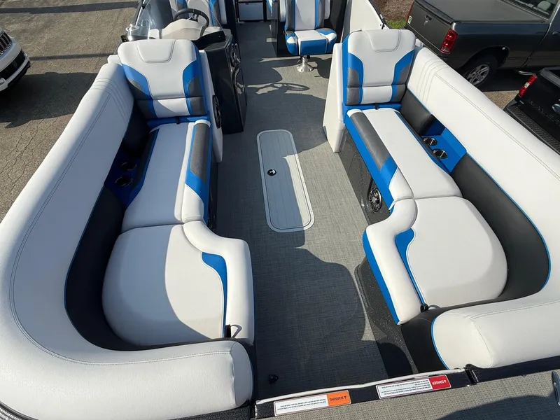 Slide: The Image of 2023 Crest Caribbean RS 230 boat interior with blue and white seating, spacious layout. - 2