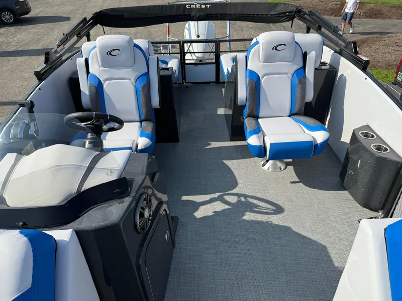 Slide: The Image of 2023 Crest Caribbean RS 230 boat interior with blue and white seating and steering console. - 4