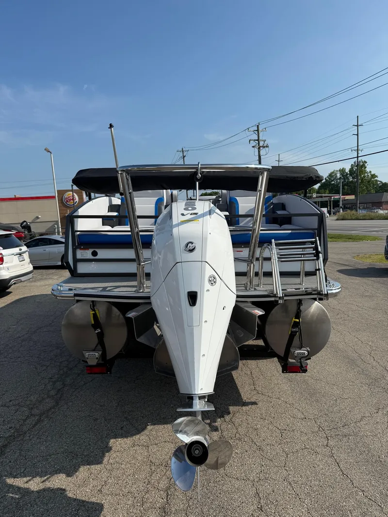 Slide: The Image of 2023 Crest Caribbean RS 230 pontoon boat with outboard motor, parked on pavement. - 9
