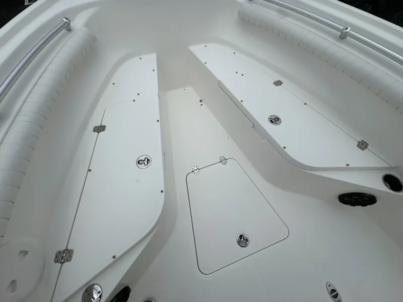 Slide: The Image of 2017 Mako 214 CC boat interior with storage compartments and cushioned seating. - 10