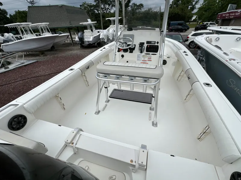 Slide: The Image of 2017 Mako 214 CC boat interior with steering console and seating, displayed outdoors. - 5