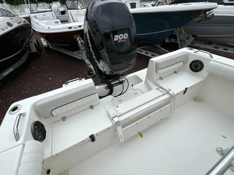 Slide: The Image of 2017 Mako 214 CC boat with 200 Pro engine, white interior, and seating area. - 6