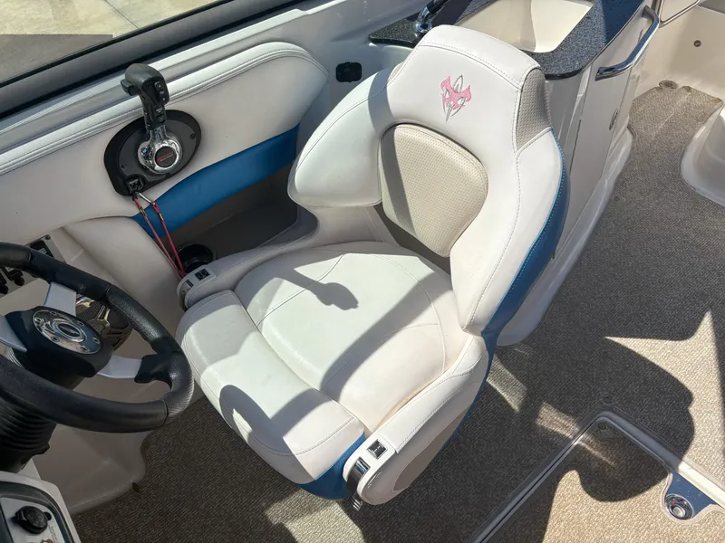 Slide: The Image of 2012 Chaparral 244 Xtreme boat interior with white captain's seat and steering wheel. - 11