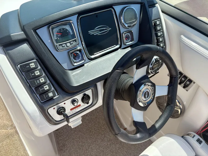 Slide: The Image of 2012 Chaparral 244 Xtreme boat dashboard with steering wheel and control panel. - 12