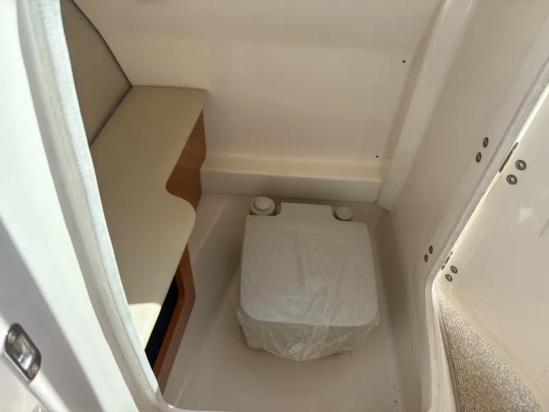 Slide: The Image of Interior of 2012 Chaparral 244 Xtreme boat with compact toilet and seating area. - 15