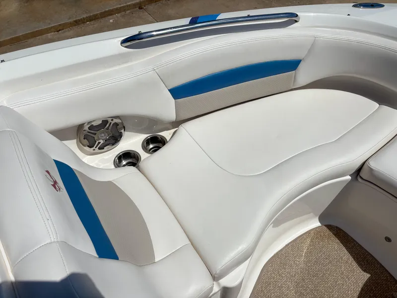 Slide: The Image of 2012 Chaparral 244 Xtreme boat interior with white and blue seating, cup holders, and speaker. - 16