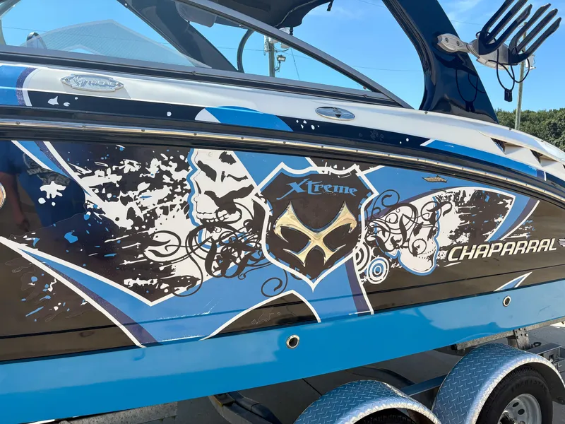 Slide: The Image of 2012 Chaparral 244 Xtreme boat with bold blue and black graphics. - 2