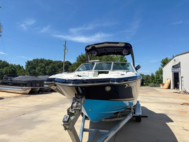 Slide: The Image of 2012 Chaparral 244 Xtreme boat on trailer, parked outdoors under clear blue sky. - 3