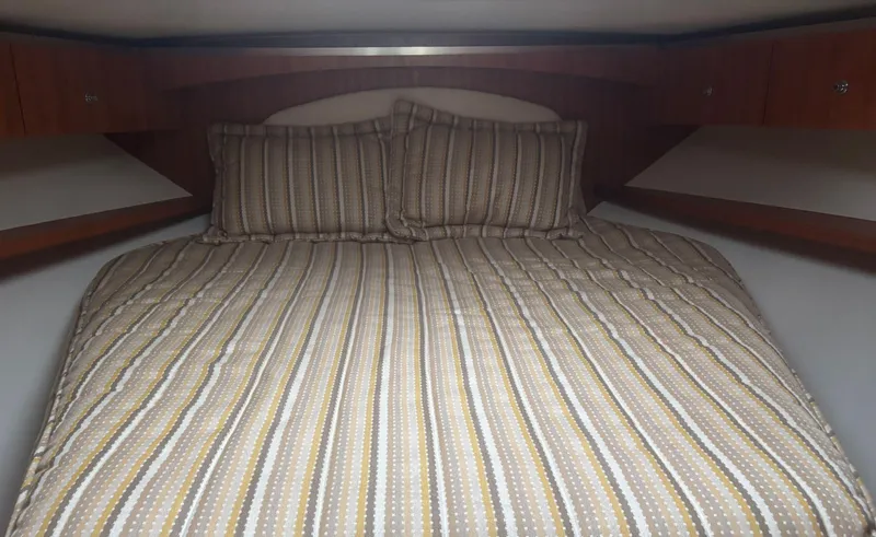 Slide: The Image of Cozy cabin bed in 2008 Tiara Yachts 3600 Open with striped bedding. - 14