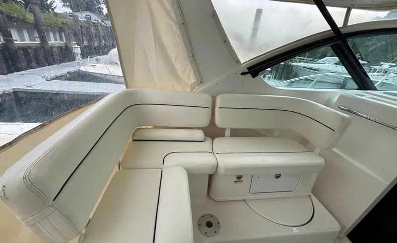 Slide: The Image of 2008 Tiara Yachts 3600 Open interior with white seating and marina view. - 7