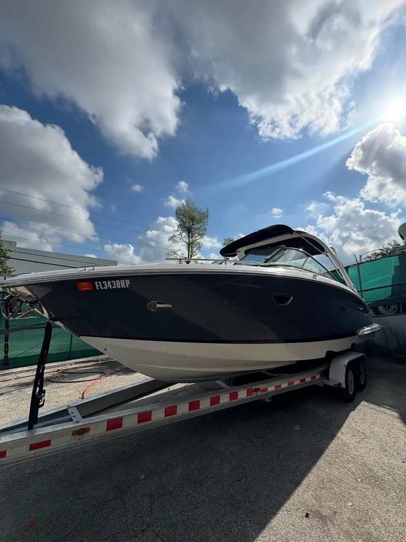 The Image of 2018 Regal 29 OBX boat on trailer under a partly cloudy sky. - 1