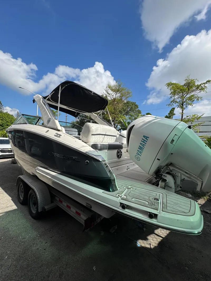 Slide: The Image of 2018 Regal 29 OBX boat with Yamaha outboard motor on trailer, under blue sky. - 10