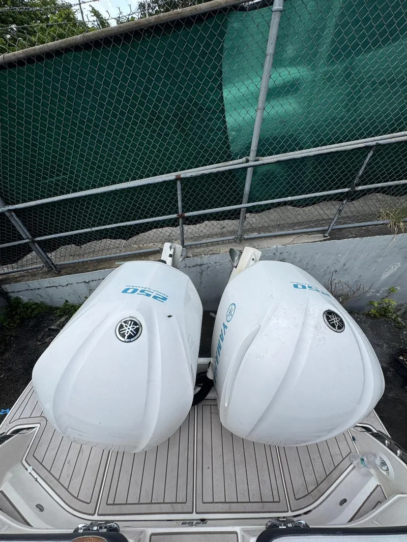 Slide: The Image of 2018 Regal 29 OBX with twin Yamaha 250 outboard engines, docked near a green fence. - 11