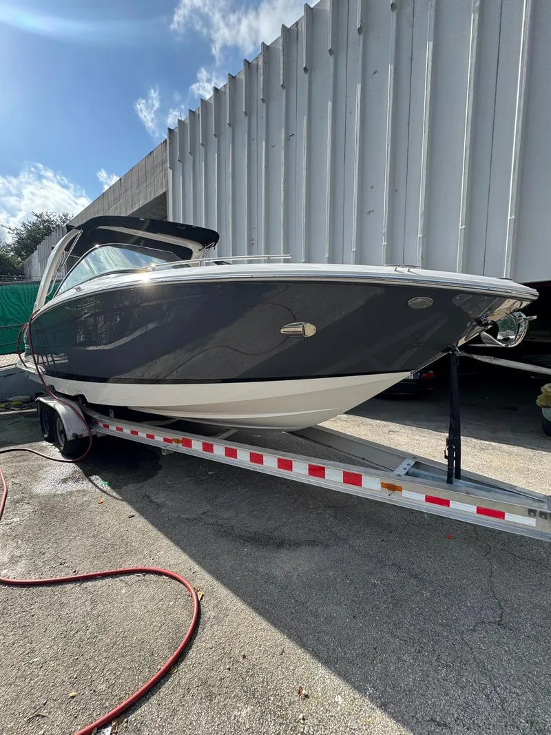 Slide: The Image of 2018 Regal 29 OBX boat on trailer, parked outdoors under a clear sky. - 2