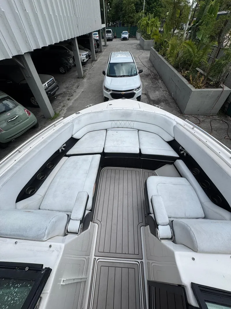 Slide: The Image of 2018 Regal 29 OBX boat with spacious seating and sleek design in a parking area. - 23