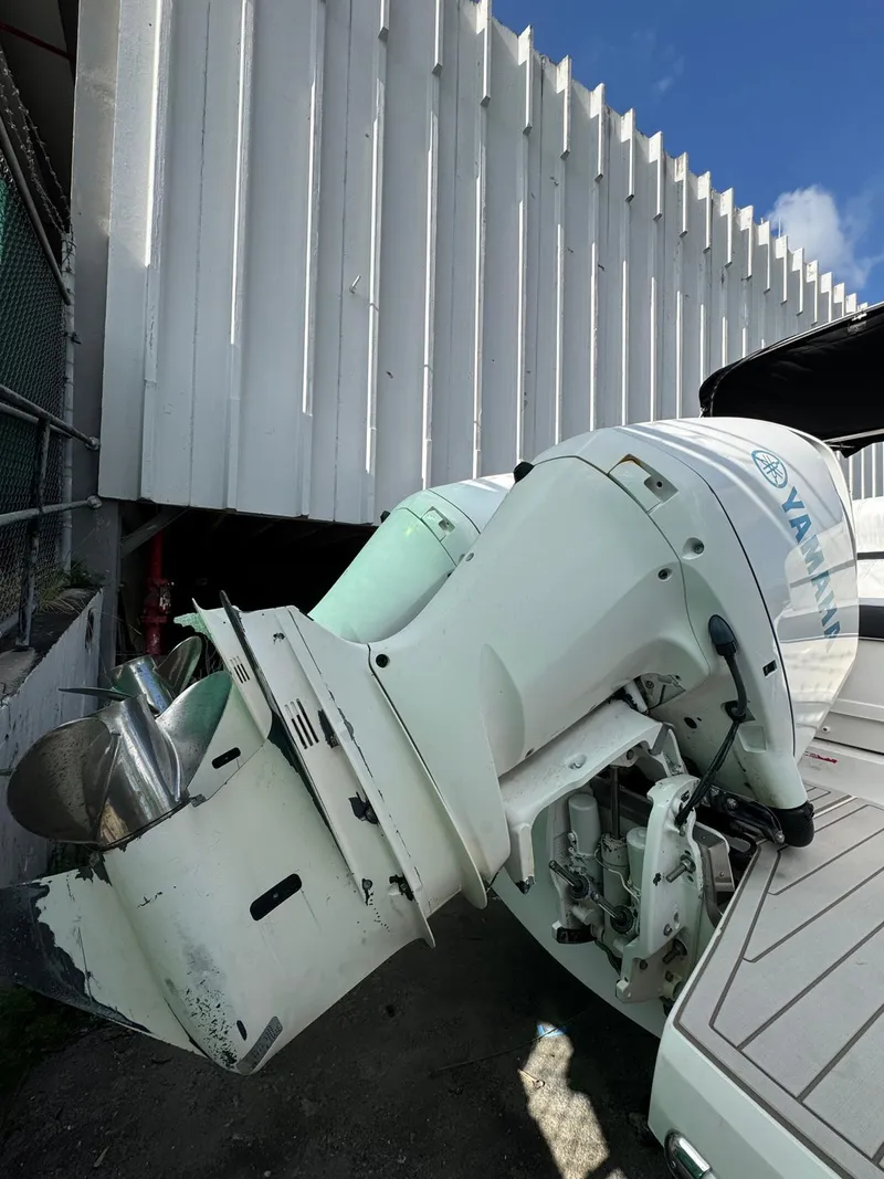 Slide: The Image of 2018 Regal 29 OBX with Yamaha outboard motor, docked near a white building. - 5