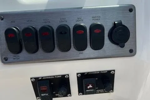 Slide: The Image of Control panel of 2014 NauticStar 223DC Sport Deck boat with switches and Johnson pump controls. - 12