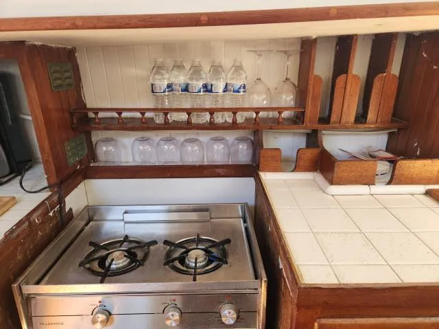 Slide: The Image of 1978 Hardin Voyager 44 yacht kitchen with stove, glassware, and tiled countertop. - 10