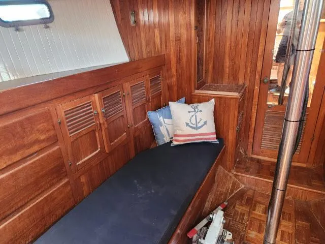 Slide: The Image of 1978 Hardin Voyager 44 interior with wooden paneling, cushioned seating, and nautical-themed pillows. - 12