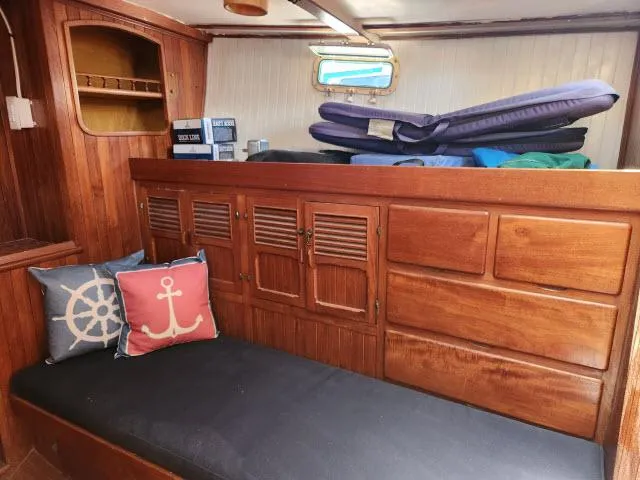 Slide: The Image of Interior of 1978 Hardin Voyager 44 sailboat with wooden cabinetry and nautical-themed cushions. - 13