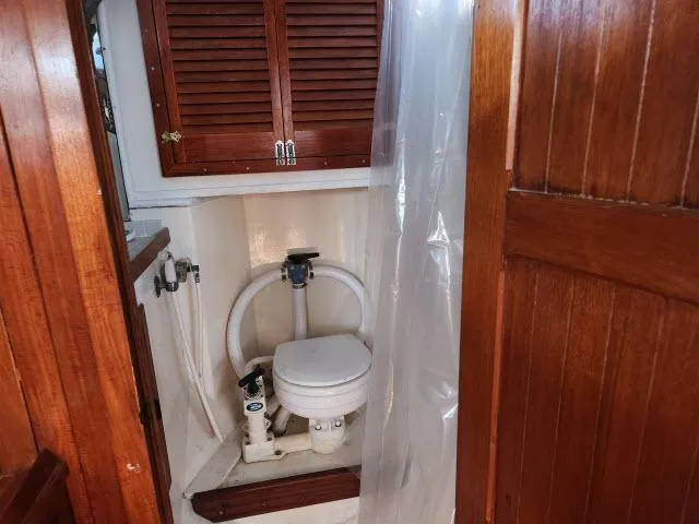 Slide: The Image of 1978 Hardin Voyager 44 boat bathroom with wooden cabinets and marine toilet. - 16