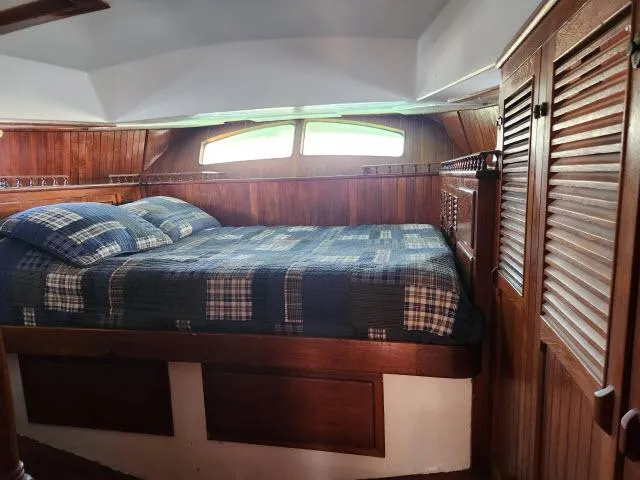 Slide: The Image of Cozy cabin interior of 1978 Hardin Voyager 44 with wooden paneling and plaid bedding. - 20