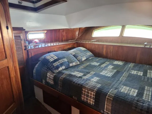 Slide: The Image of Cozy cabin interior of 1978 Hardin Voyager 44 with plaid bedding and wooden accents. - 21