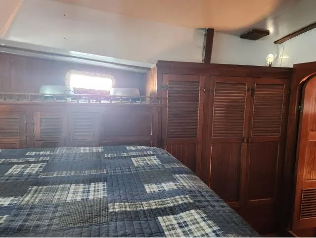 Slide: The Image of Cozy cabin interior of 1978 Hardin Voyager 44 with wooden cabinets and plaid bedding. - 22