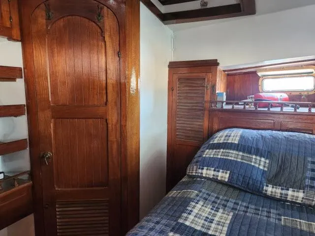 Slide: The Image of Cozy cabin interior of 1978 Hardin Voyager 44 with wooden paneling and plaid bedding. - 23