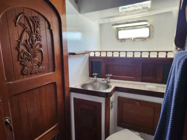 Slide: The Image of 1978 Hardin Voyager 44 bathroom with wooden door, sink, and porthole window. - 24