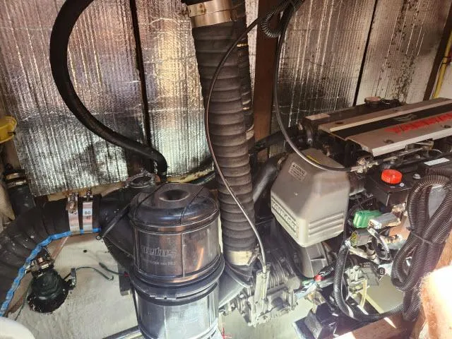 Slide: The Image of Engine room of a 1978 Hardin Voyager 44 sailboat, featuring mechanical components and hoses. - 37