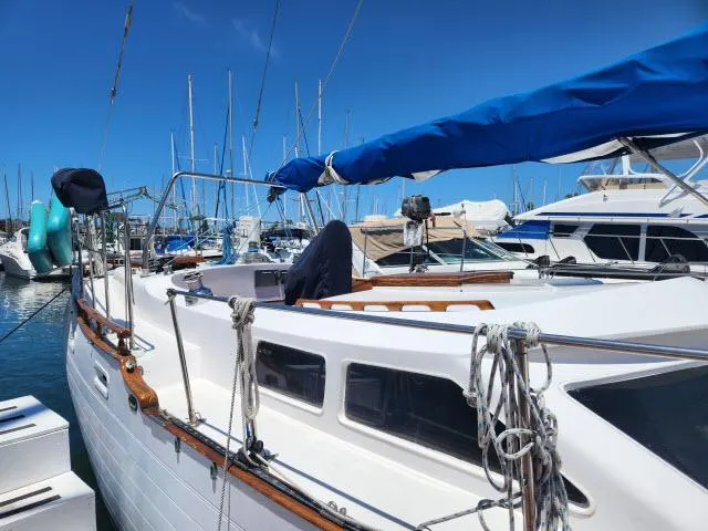 Slide: The Image of 1978 Hardin Voyager 44 sailboat docked in a marina under clear blue skies. - 48