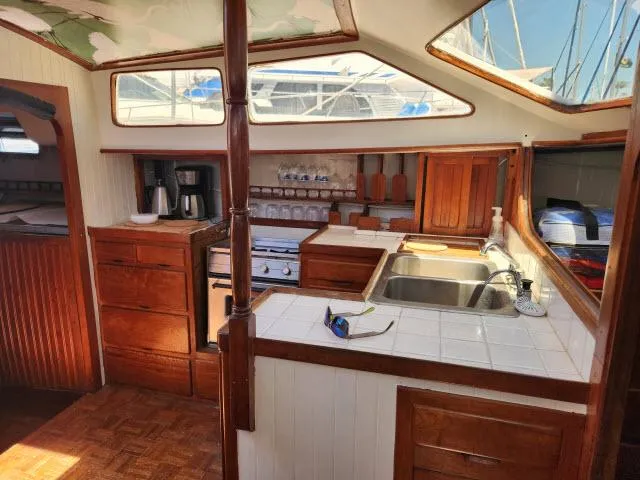 Slide: The Image of Interior of 1978 Hardin Voyager 44 sailboat with wooden cabinetry and kitchen amenities. - 8