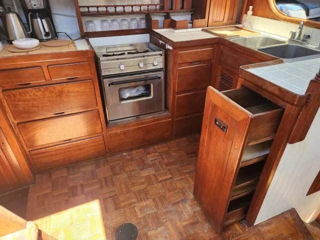 Slide: The Image of 1978 Hardin Voyager 44 yacht kitchen with wooden cabinets, stove, and sink. - 9