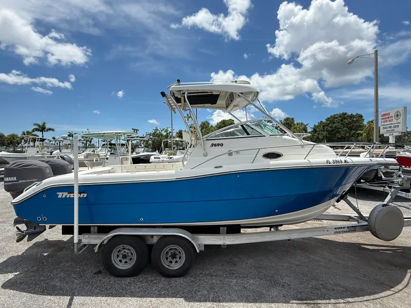 Slide: The Image of 2004 Triton 2690 WA boat on trailer under a clear blue sky. - 0
