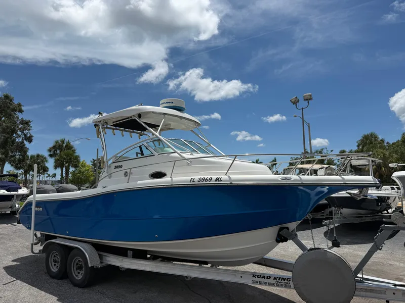 Slide: The Image of 2004 Triton 2690 WA boat on trailer under clear blue sky. - 1