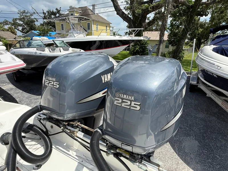 Slide: The Image of Twin Yamaha 225 outboard engines on a 2004 Triton 2690 WA boat, parked outdoors. - 13