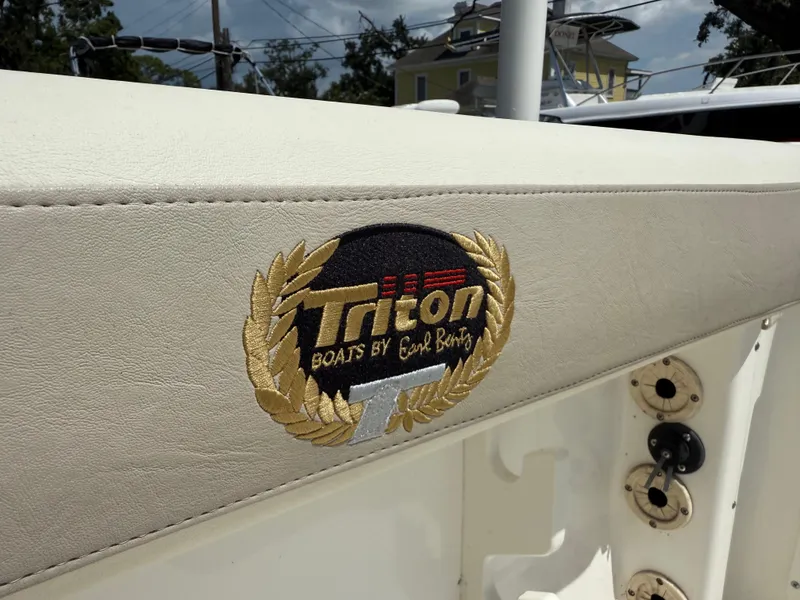 Slide: The Image of 2004 Triton 2690 WA boat logo on white upholstery with gold laurel design. - 23