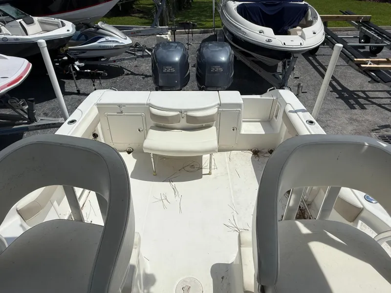 Slide: The Image of 2004 Triton 2690 WA boat interior with dual Yamaha 225 engines, docked among other boats. - 31