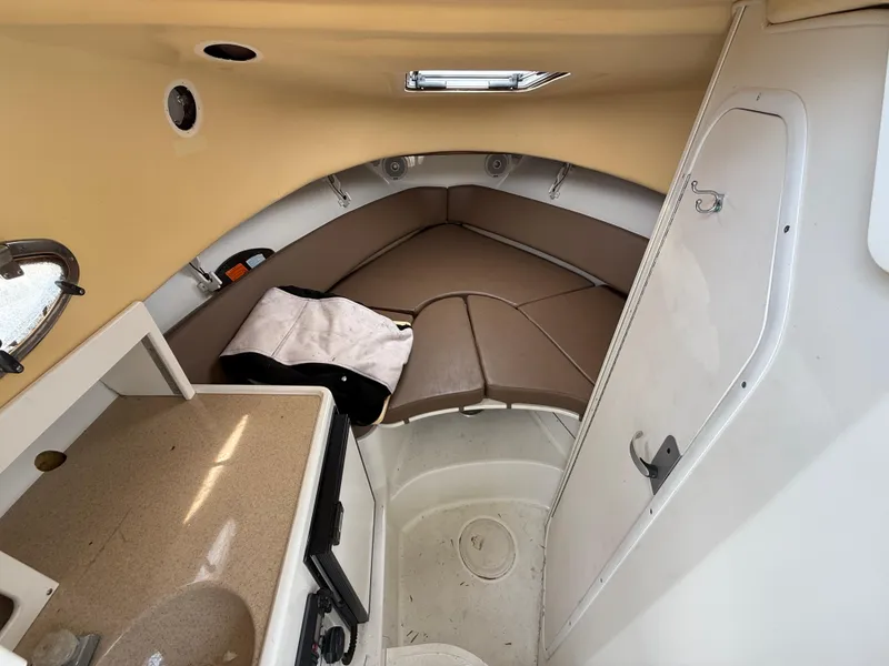 Slide: The Image of 2004 Triton 2690 WA cabin interior with beige seating and compact kitchenette. - 36