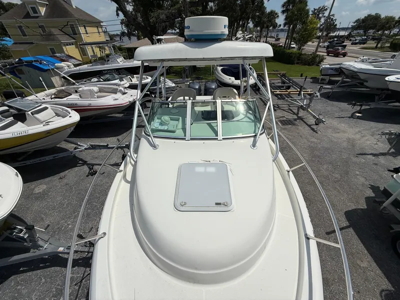 Slide: The Image of 2004 Triton 2690 WA boat on trailer, surrounded by other boats in a marina. - 38